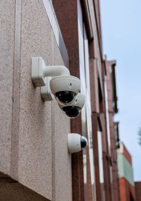 A vertical shot of security cameras on the side of a building